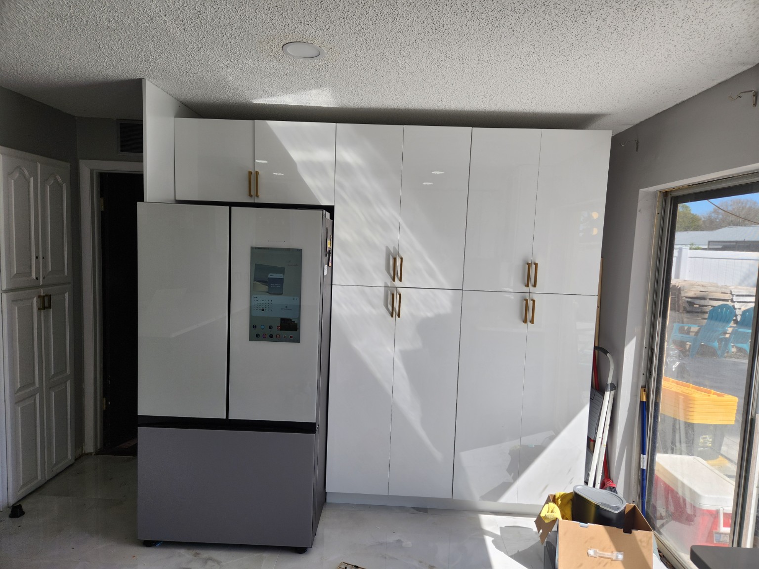After photo of tall white storage cabinets next to refrigerator