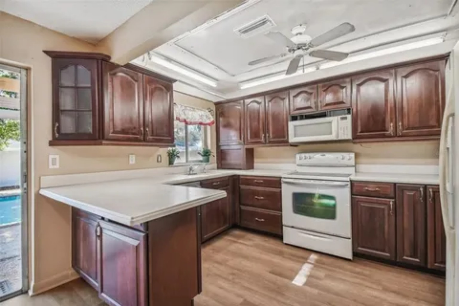 Before photo of original kitchen with dark wood cabinets